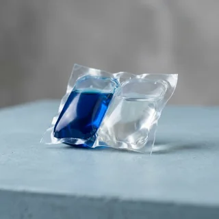 Cápsulas monodose de detergente líquido em filme solúvel, uma com líquido azul